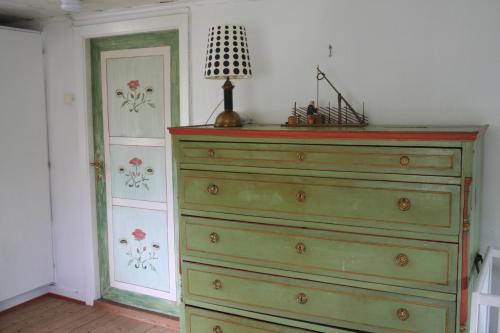 a green dresser with a lamp on top of it at Kylås Vildmark in Skillingaryd