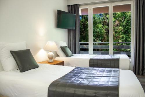 a hotel room with two beds and a window at Garden & City Capvern-les-Bains in Capvern