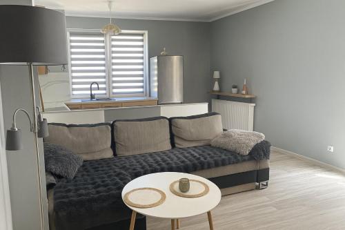 a living room with a couch and a table at Apartament Mazury Węgorzewo in Węgorzewo