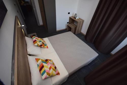 a bed with two pillows on it in a room at New Comfort Apartment Igea Marina in Bellaria-Igea Marina
