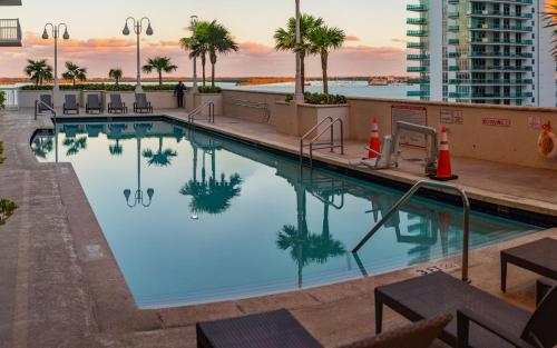 a pool on the roof of a building with palm trees at Studios in Brickell with Pool, Gym, free parking and Game Room in Miami