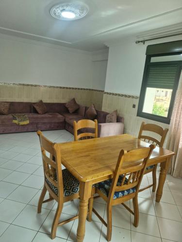 a dining room with a wooden table and chairs at Très bonne appartement au cœur d'Oujda in Oujda