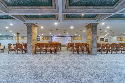 a room with a bunch of chairs and a projection screen at May Termal Pamukkale in Pamukkale