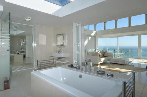 baño grande con bañera grande y ventana grande en Simply Stunning, en Yzerfontein