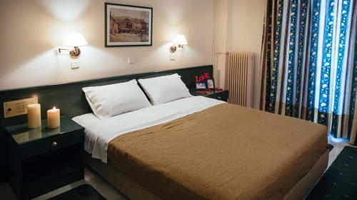 a bedroom with a bed with two candles on it at Ignatia Hotel in Nafplio