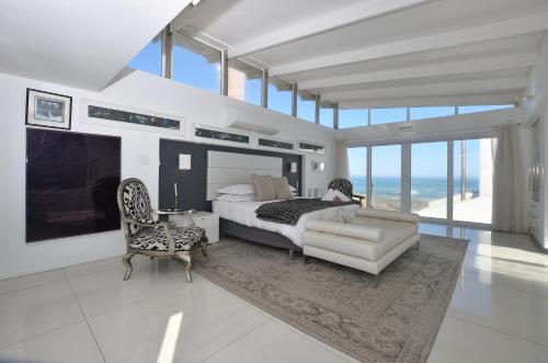 Un dormitorio con una cama, un sofá y una silla. en Simply Stunning, en Yzerfontein