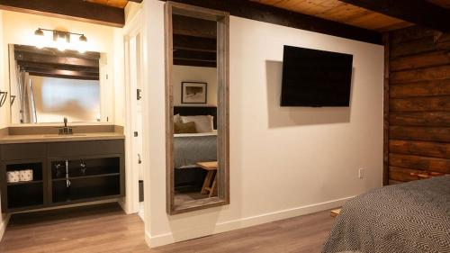 a bedroom with a bathroom with a sink and a mirror at High Creek Lodge and Cabins in Pagosa Springs