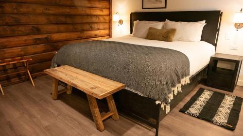 a bedroom with a large bed with a wooden wall at High Creek Lodge and Cabins in Pagosa Springs