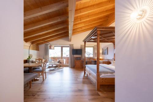 a bedroom with a bed and a dining room at Hotel Stubaierhof in Neustift im Stubaital