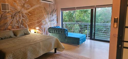 Un dormitorio con una cama y una silla y una ventana. en Alimandi Villa, en Klapmuts