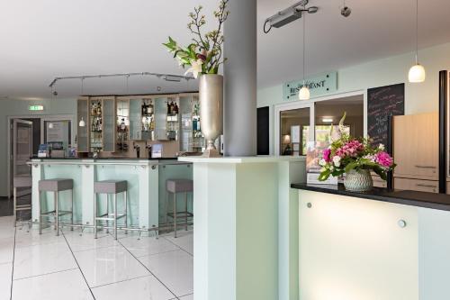 a bar in a restaurant with blue counters and stools at Garner Hotel Oberhausen in Oberhausen