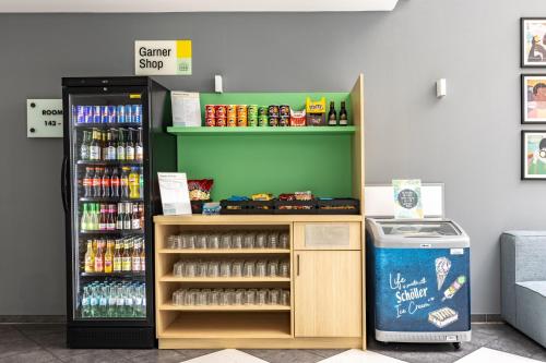 a store with a drink cooler next to a soda at Garner Hotel Oberhausen in Oberhausen