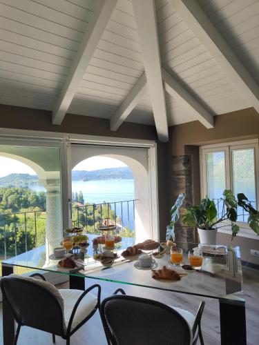 a table with food on it in a room with windows at Villa Antica Colonia SPA & Wellness in Pettenasco