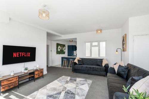 a living room with a couch and a tv at Clarence Square 2 Bedroom Central in Brighton & Hove