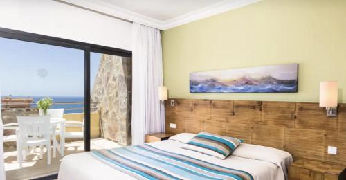 a bedroom with a bed and a view of the ocean at Apartamento Espectacular con Vistas al Mar en Bahía Feliz in Playa del Aguila