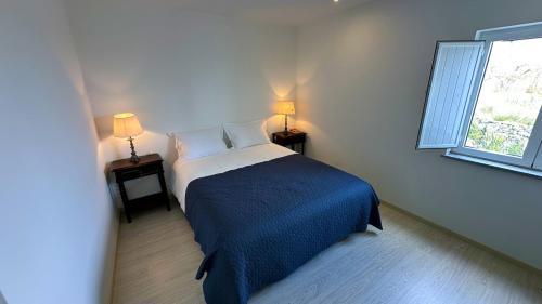 a bedroom with a bed and two tables with lamps at Casas Fonte da Tapada - Casa da Mina in Trancoso