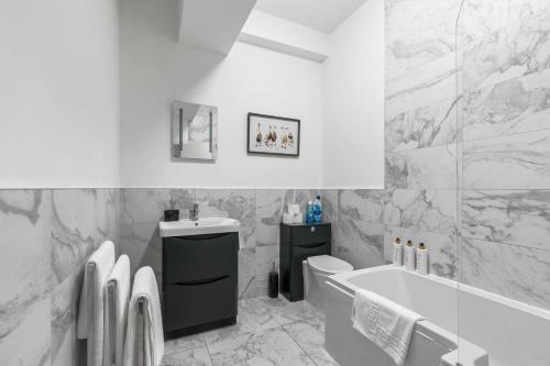 Un baño con bañera, inodoro y lavabo. en Clarence Square 2 Bedroom Central, en Brighton & Hove