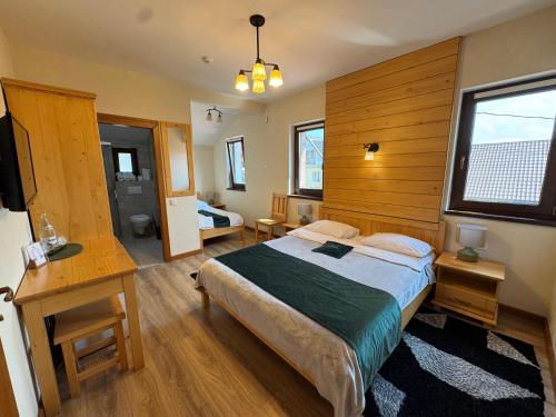 a bedroom with a bed and a desk and a television at Villa Montana Borsec - Vedere Munte in Borsec