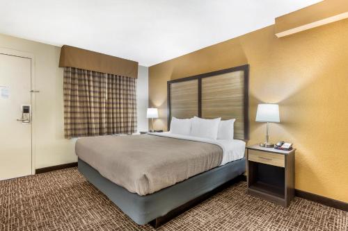 a hotel room with a large bed and a window at Quality Inn & Suites Spring Lake - Fayetteville near Fort Bragg in Spring Lake