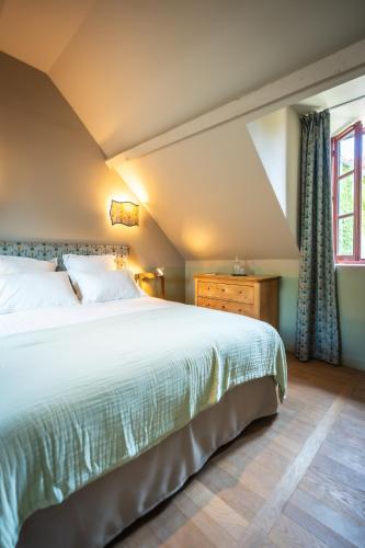 a bedroom with a large bed and a window at Le Domaine de Richebourg - Pierres d'Histoire in Richebourg
