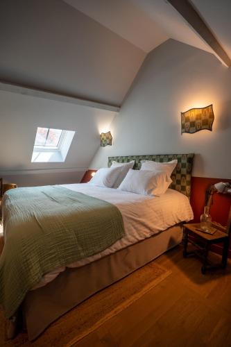 a bedroom with a large bed in a attic at Le Domaine de Richebourg - Pierres d'Histoire in Richebourg