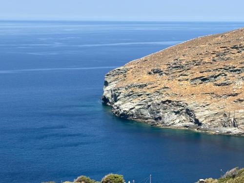 a large body of water next to a cliff at Cavo Levante in Andros