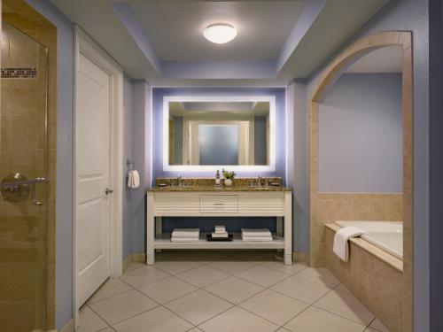 a bathroom with a sink and a tub and a mirror at Hyatt Regency Clearwater Beach Resort & Spa in Clearwater Beach