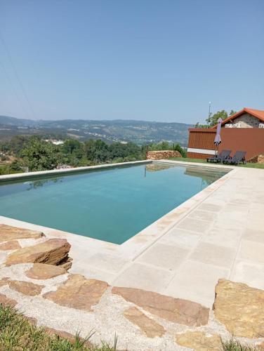 a swimming pool with blue water at Quinta das Mimosas in Mondim de Basto