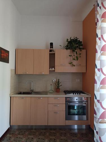 a kitchen with wooden cabinets and a stove at Dimora FinAmore 29 - Casa Vacanze in Lanciano