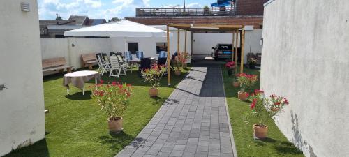 a patio with potted plants and tables and an umbrella at B&b Broodhuis Kerkrade in Kerkrade