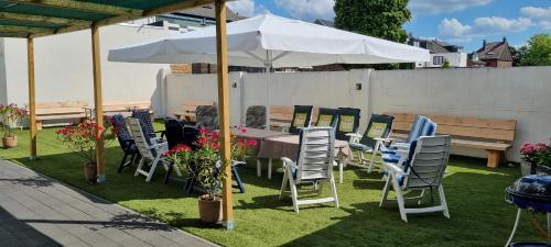 a table and chairs under an umbrella on the grass at B&b Broodhuis Kerkrade in Kerkrade