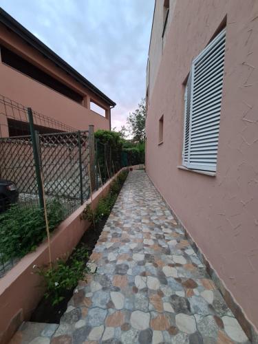 a stone walkway next to a building with a fence at Emanuela Appartaments in Furnari