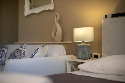 a living room with a couch and a table with a lamp at Diego Pool-Suite in Gello