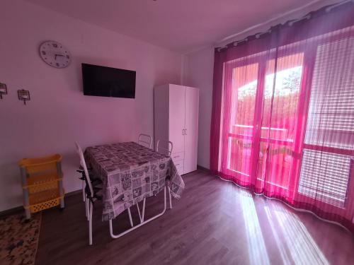 a room with a bed and a window with pink curtains at Emanuela Appartaments in Furnari