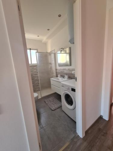 a bathroom with a washing machine and a sink at Emanuela Appartaments in Furnari