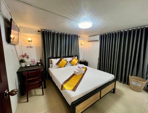 a bedroom with a bed and a chair in it at Sun Chakra Boutique Hotel - 50m to Museum & Royal Palace & Walking street in Phnom Penh