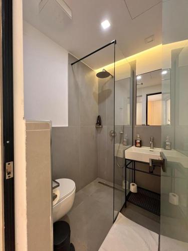 a bathroom with a shower and a toilet and a sink at Green Condo Hotel Palase in Palasë