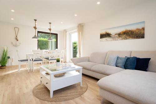 a white living room with a couch and a table at Landhaus Ostseeglück in Dahme