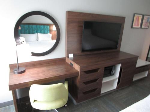 a bedroom with a desk with a tv and a mirror at Best Western Cy-Fair in Houston
