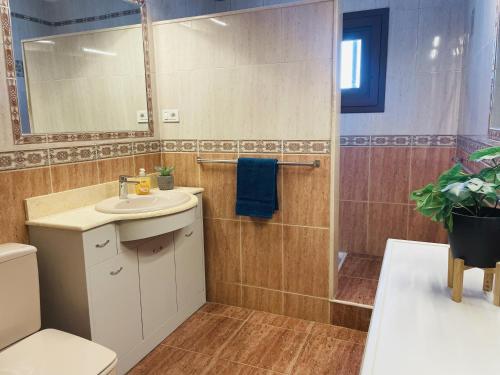 ein Badezimmer mit Waschbecken, Toilette und Spiegel in der Unterkunft Horizonte Azul in Tías