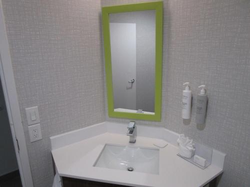 a bathroom with a sink with a green mirror at Best Western Cy-Fair in Houston