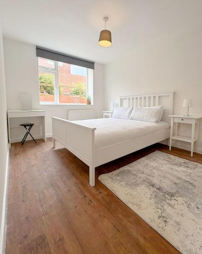 a white bedroom with a bed and a window at 58d Thorpe road in Norwich