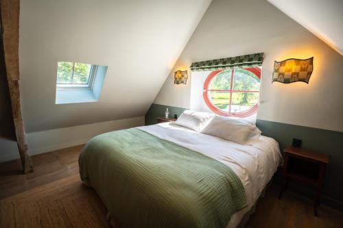 a bedroom with a large bed with two windows at Le Domaine de Richebourg - Pierres d'Histoire in Richebourg