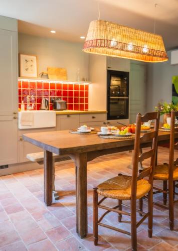 a kitchen with a wooden table and chairs at Le Domaine de Richebourg - Pierres d'Histoire in Richebourg