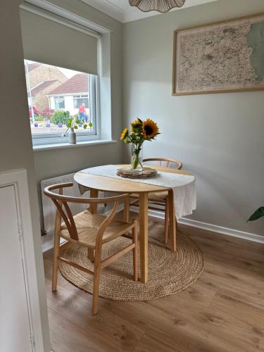 a table and chairs with a vase of flowers on it at Cosy home for 2 in Alnwick in Alnwick