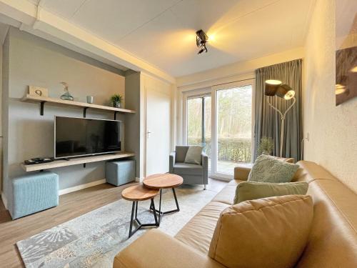 a living room with a couch and a tv at Appartementen Bos en Duin Texel in Den Hoorn