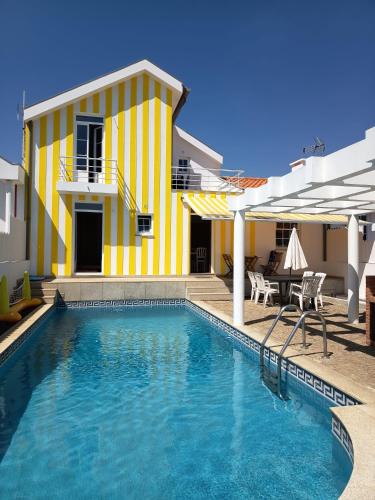 a yellow and white house with a swimming pool at Villa Nenúfares in Torreira