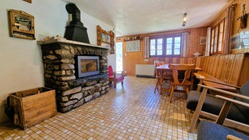 a living room with a stone fireplace and a table at Chalet l Houtot in Evolène