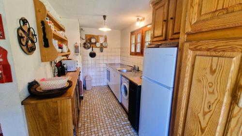 a kitchen with a white refrigerator and a sink at Chalet l Houtot in Evolène