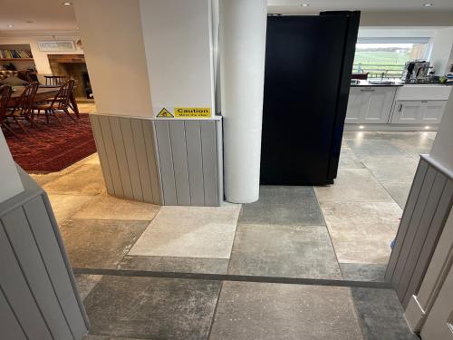 a lobby with a sign that says caution on the floor at 5 Bed in Anstruther 83504 in Pittenweem